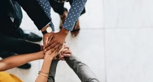 Business people putting hands in together.