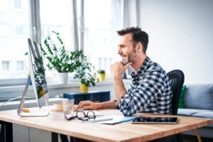 man smiling at computer