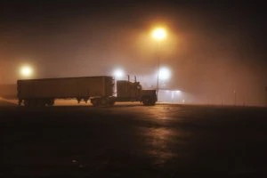 tractor trailer parked in empty, dark parking  lot
