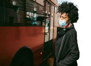 woman wearing medical mask boarding a bus.