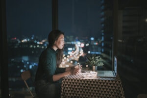 Woman having a date at a table with a laptop.