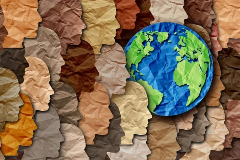 Earth Day Diversity - Blue and Green Globe surrounded by silhouetted faces in shades of flesh and browns