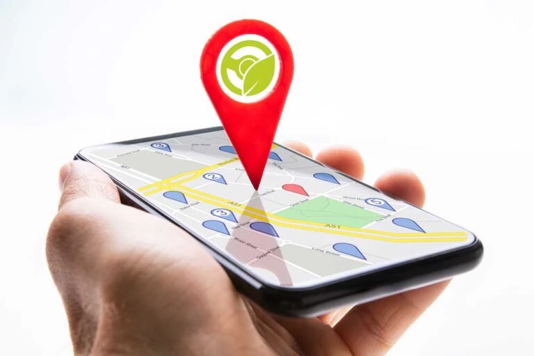 Human hand holding cellphone with Navigation app showing on screen