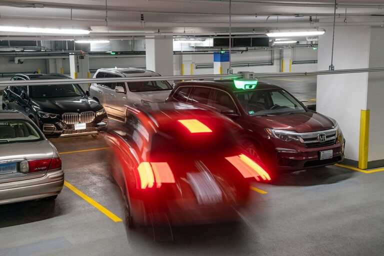 Blurred red car pulling into an indoor parking space