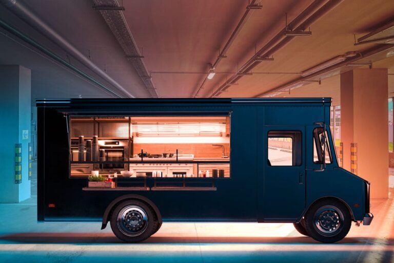 Food truck parked in a parking garage, with the side windows open and lit up