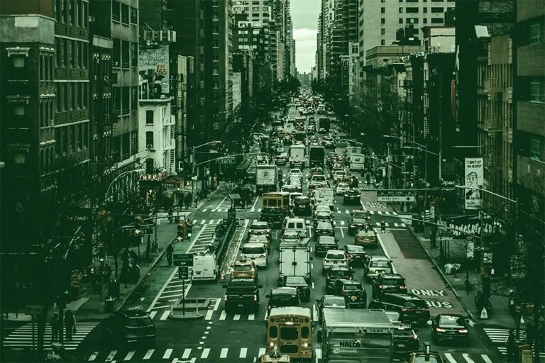 Black and white photo of a very busy city street.