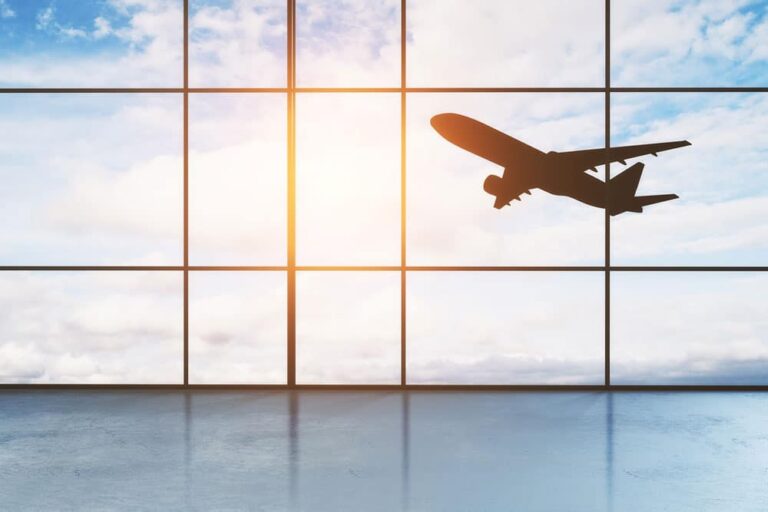 Airport windows looking out at aircraft taking off