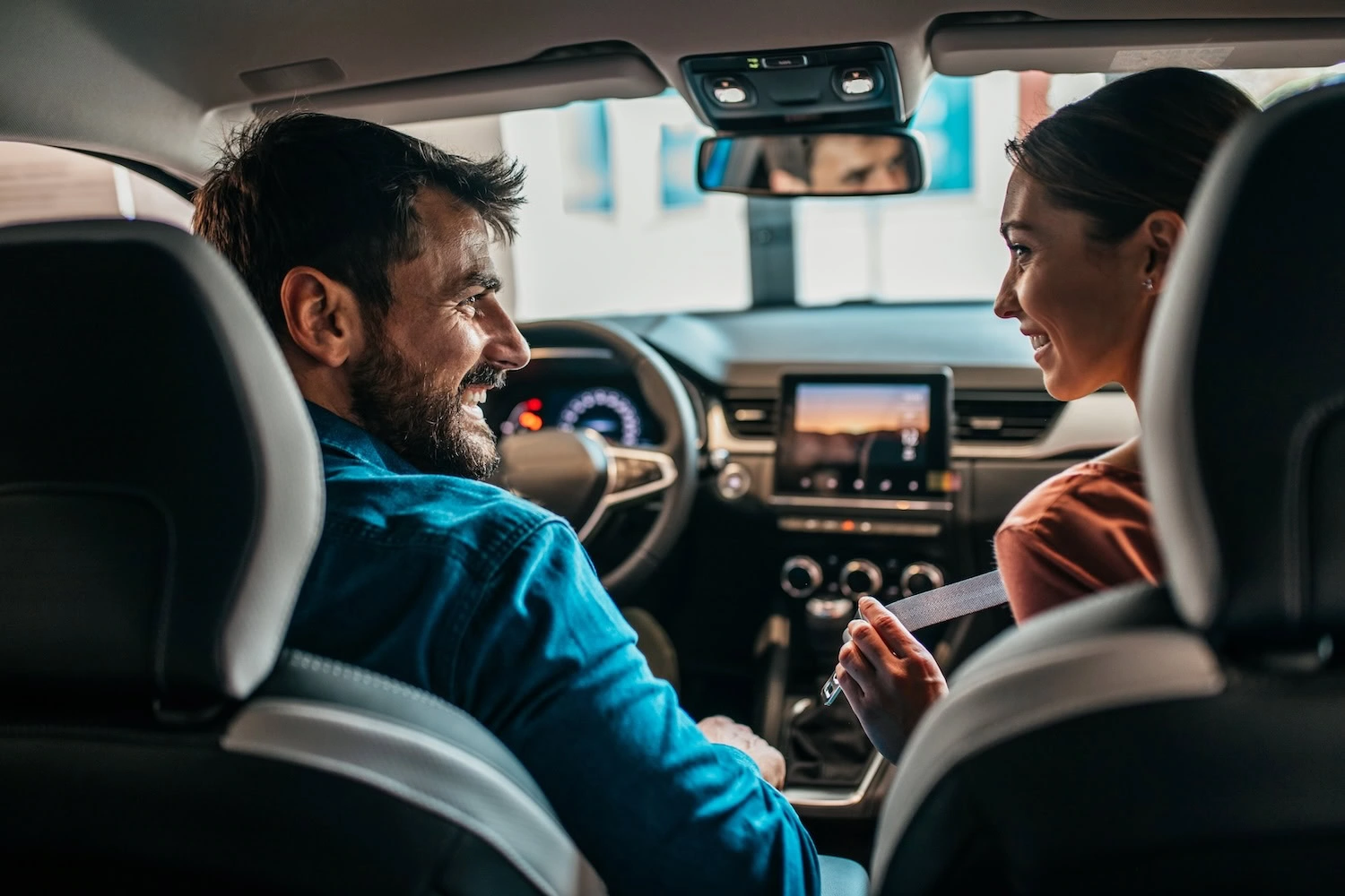 Young couple at car showroom choosing a new car to buy.