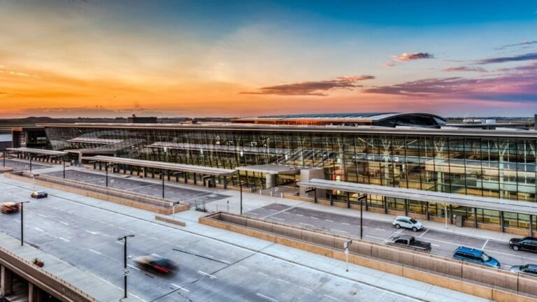 A large parking garage under construction near a highway