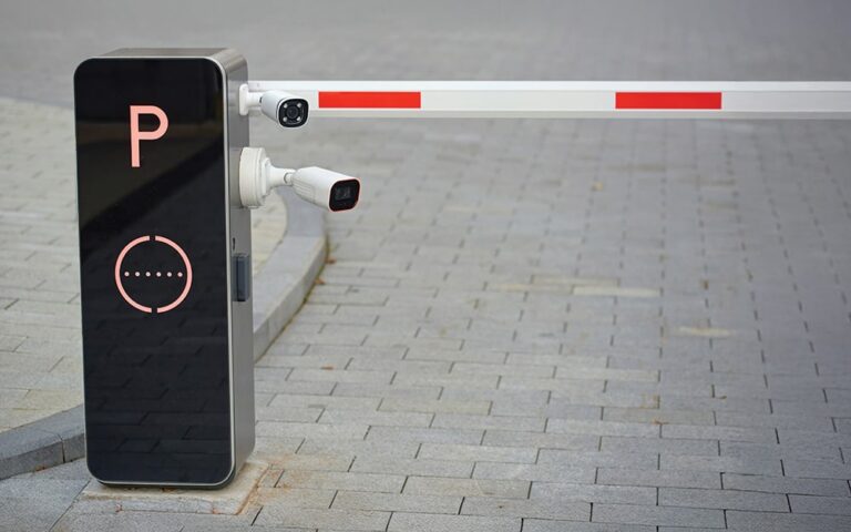 Entrance to a parking lot with an electronic license reader working an arm to allow entrance to the lot