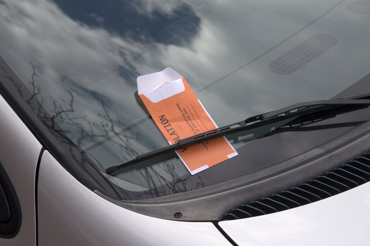 This image is of a car windshield with an orange parking ticket.